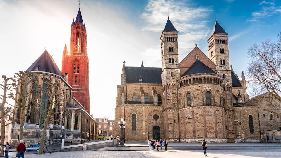 Une église historique dotée de deux tours imposantes et d’un clocher rouge.