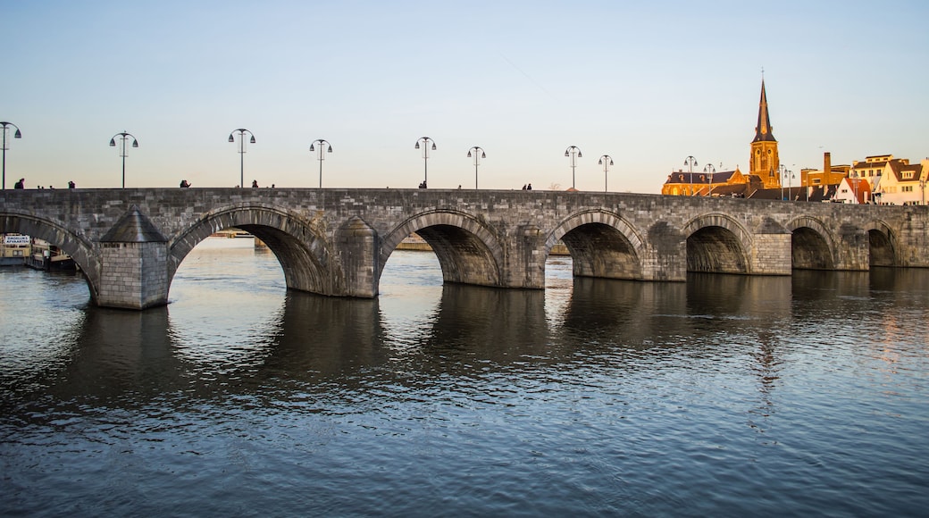 Eine Stebrücke über Wasser, im Hintergrund eine Kirche.