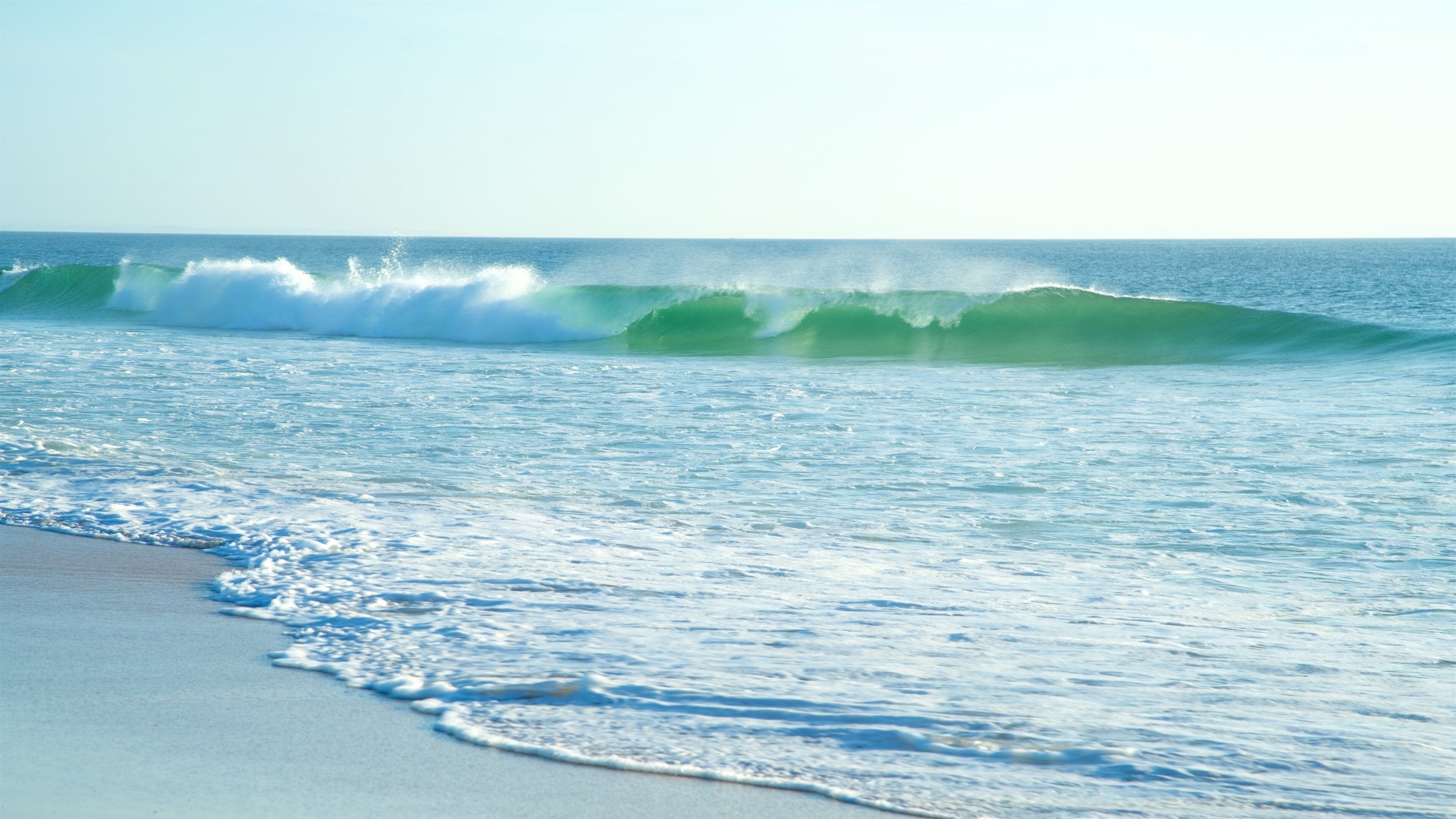 A beach with waves crashing onto the shore.
