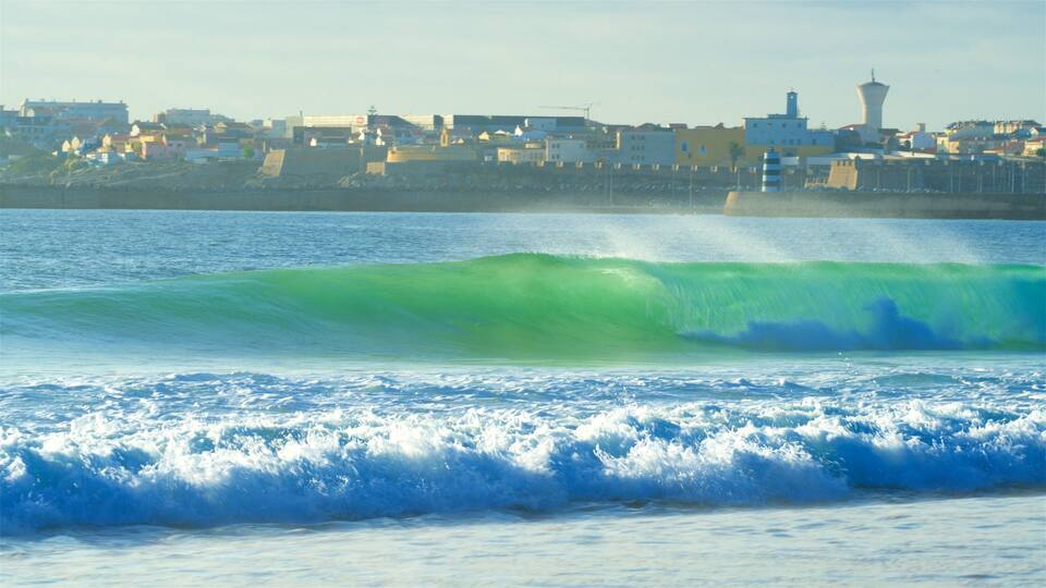 A coastal cityscape with a prominent lighthouse and a large wave in the foreground.