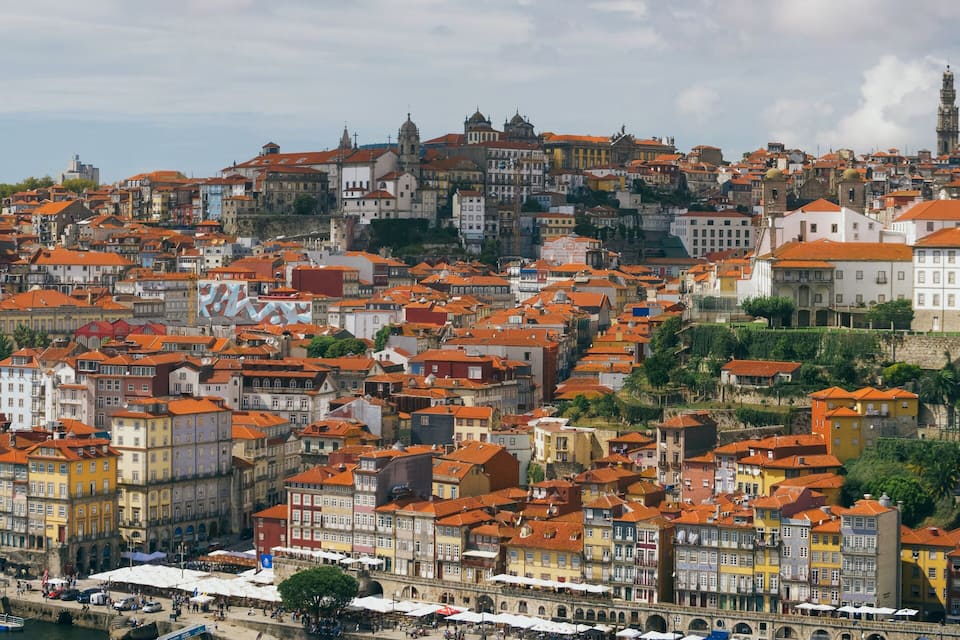 A densely packed hillside cityscape with historic buildings and a prominent church.