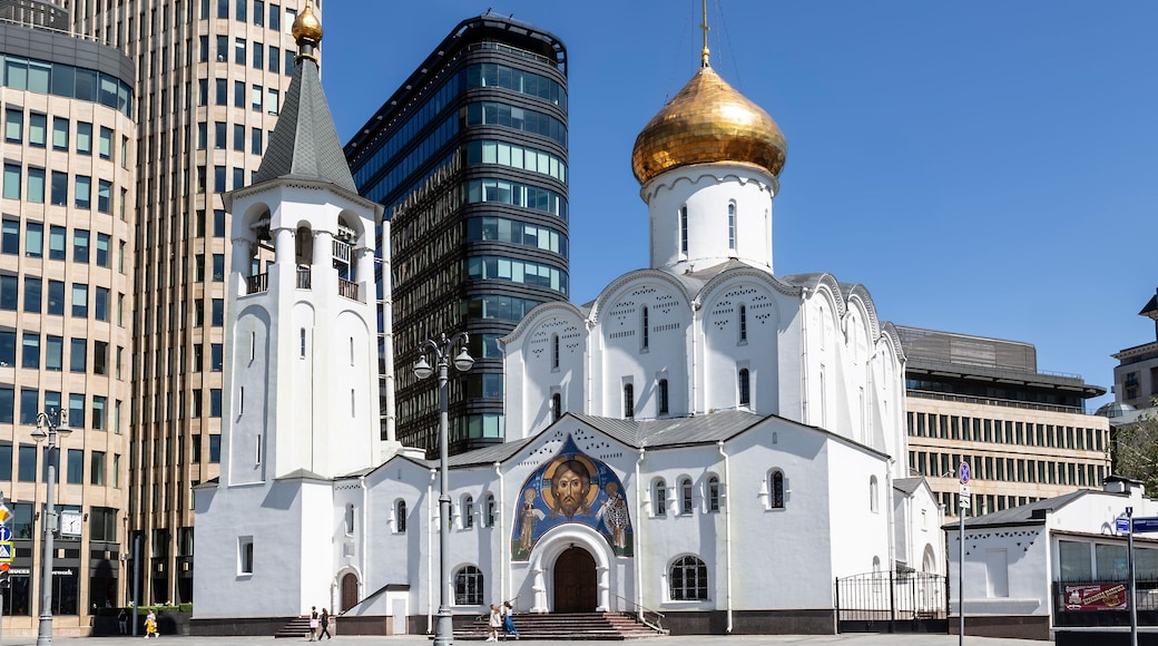 A white church with a golden dome and a large mural on the facade.