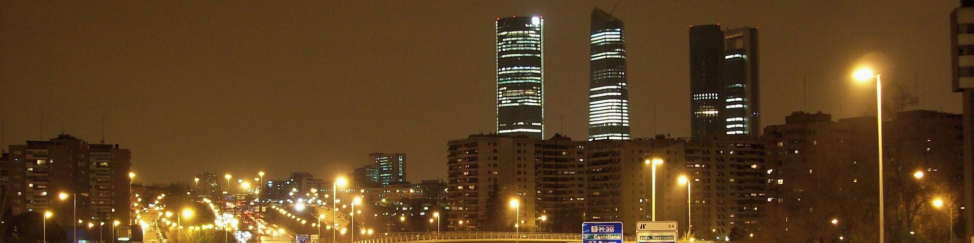A nighttime cityscape with multiple highways and illuminated buildings.