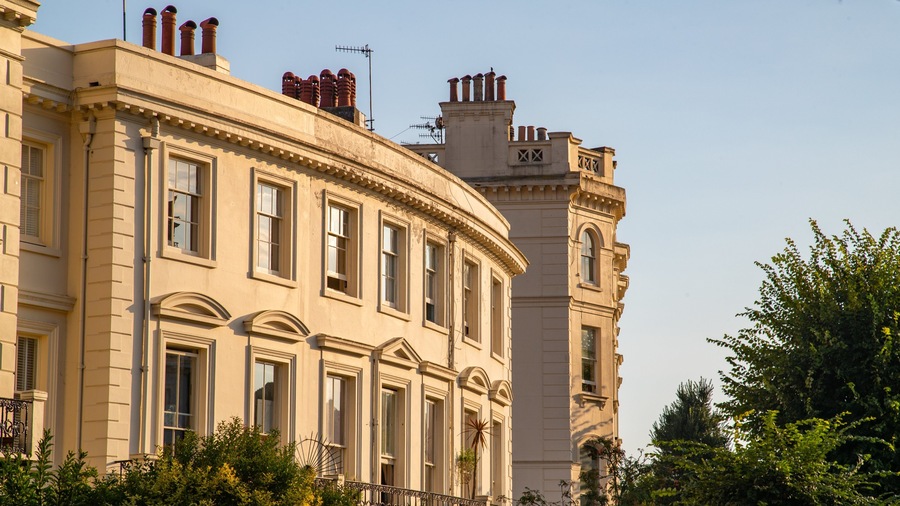A classical building with multiple chimneys and arched windows.