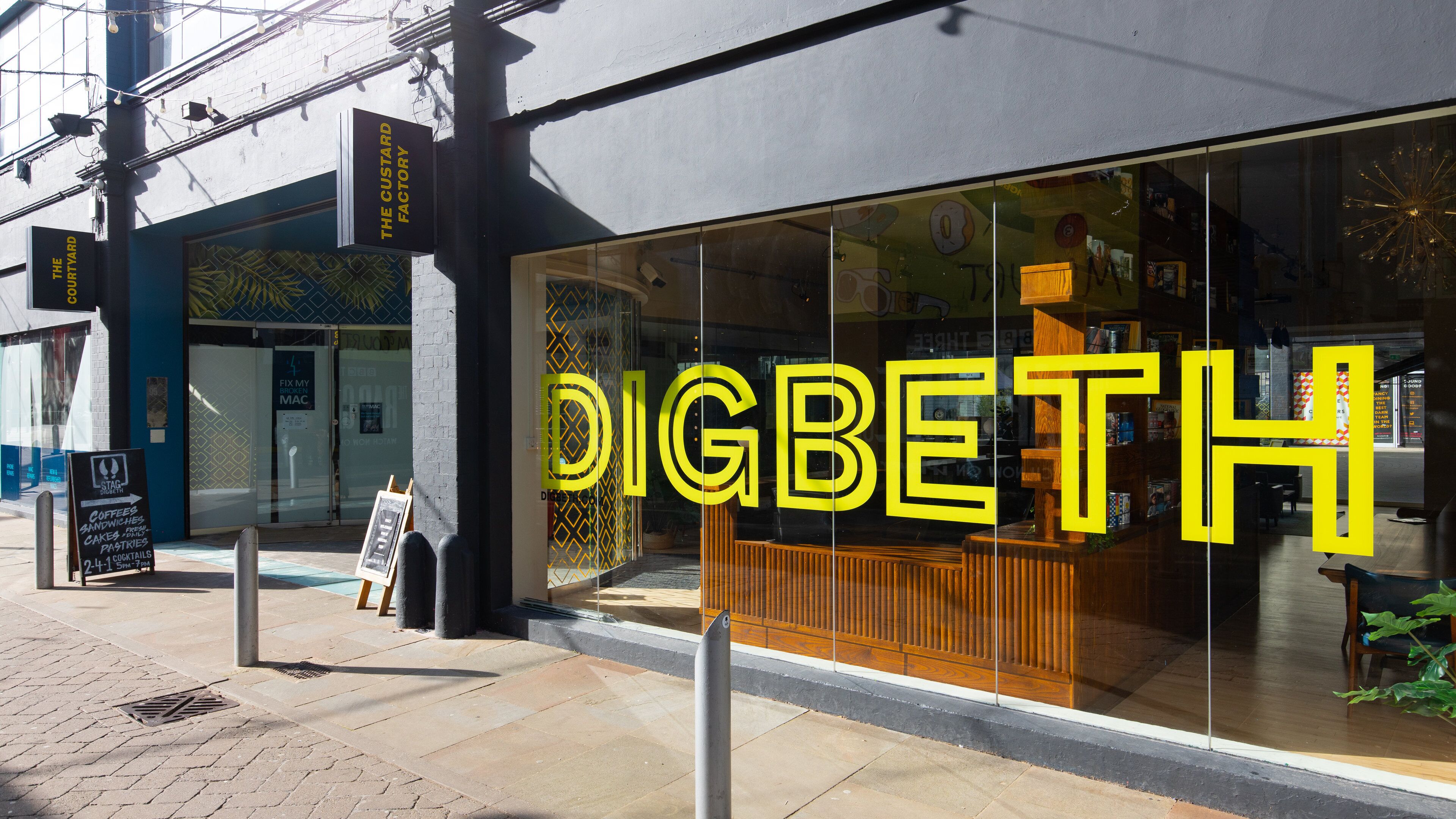 A storefront with a large illuminated sign reading "DIGBETH".