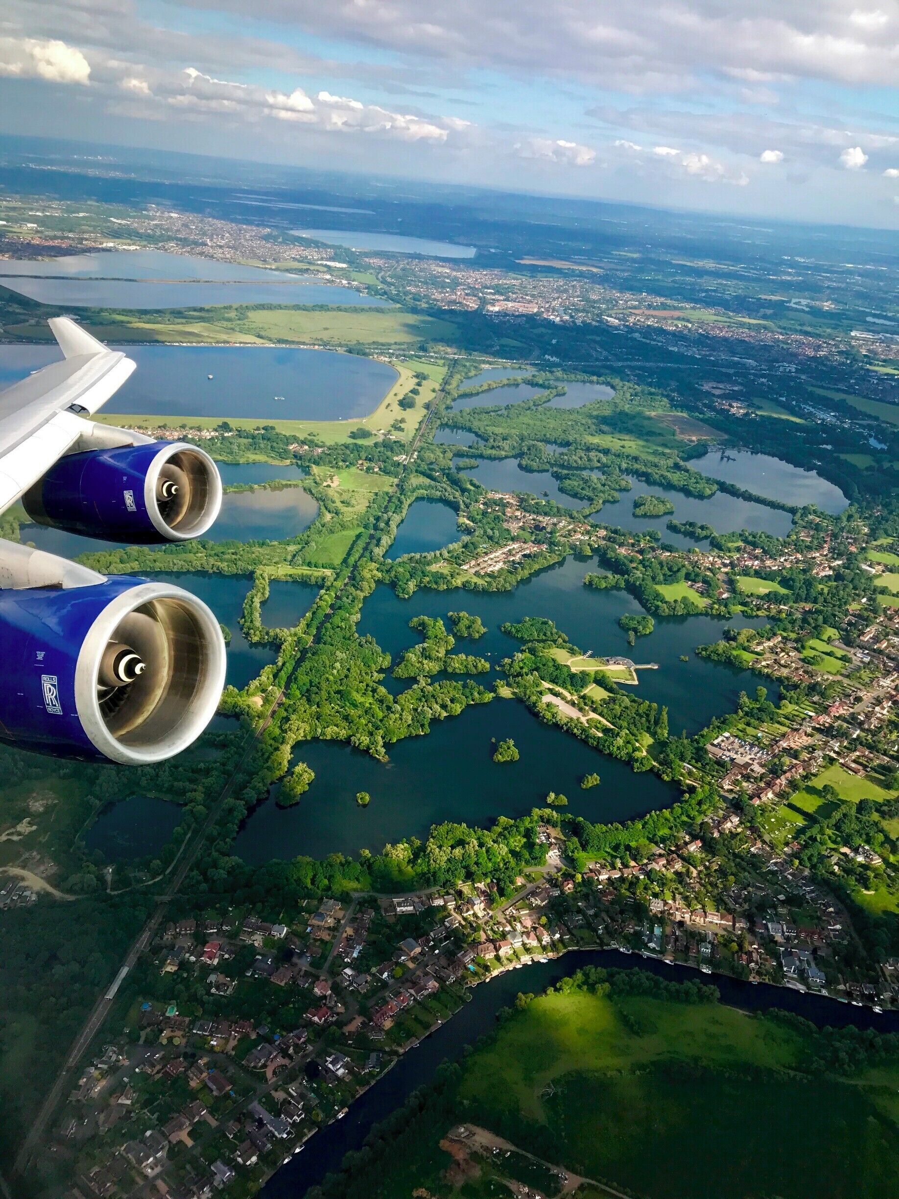 An aerial view of a city with multiple lakes and green areas.