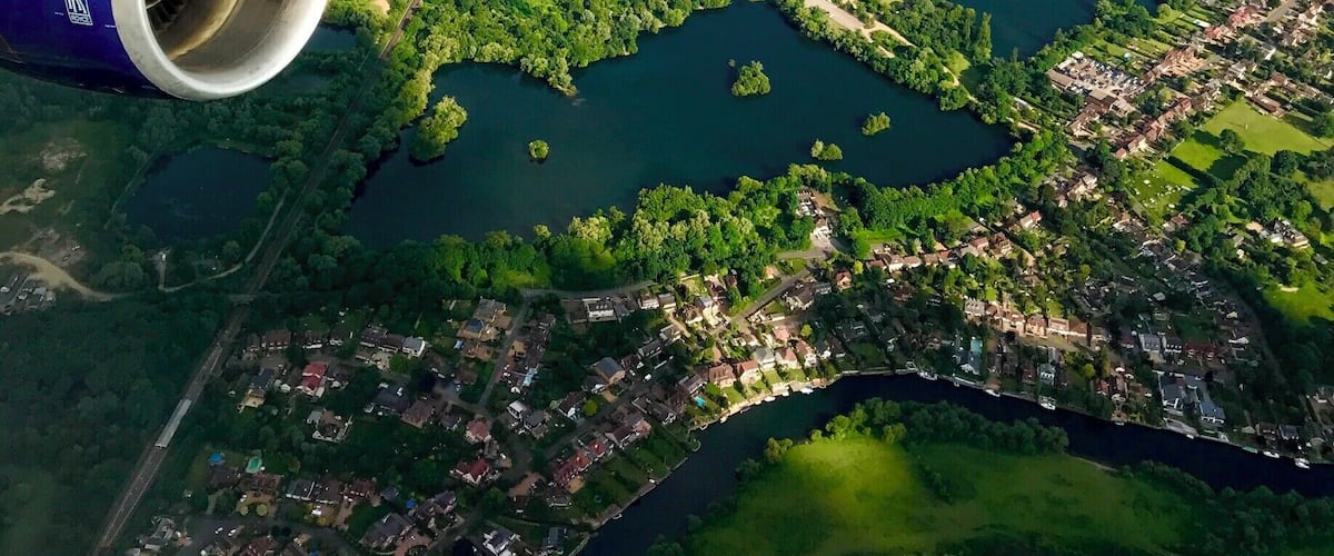 An aerial view of a city with multiple lakes and green areas.