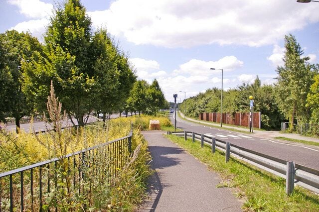 Footpath to bridge over North Circular Road Looking west from the footpath leading to the bridge over the North Circular Road. On the right we have Atlas Road and on the left behind the trees the eastbound carriage of the North Circular Road (A406). The Friern Park Trading Estate has a one way system of access and exit.