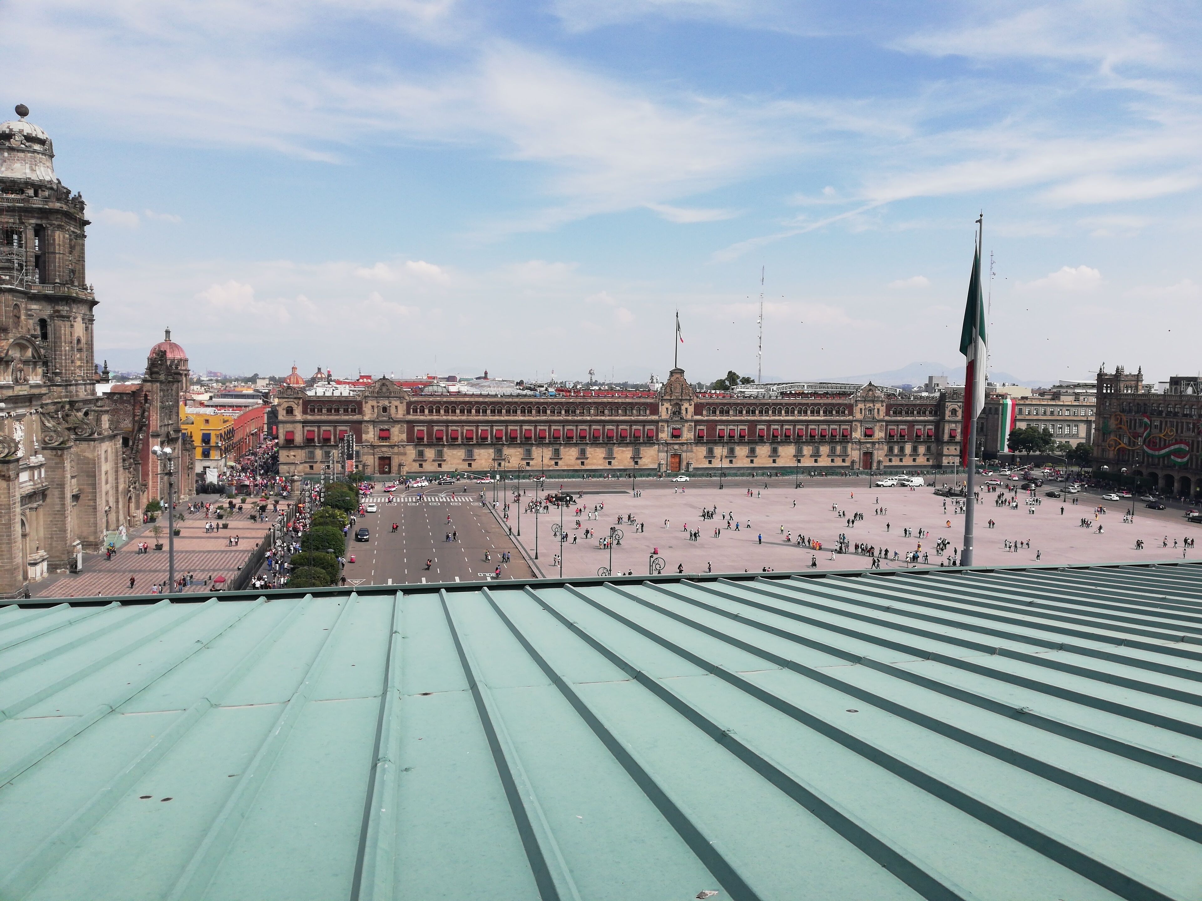 Um edifício histórico grande com um pátio central e um mastro.