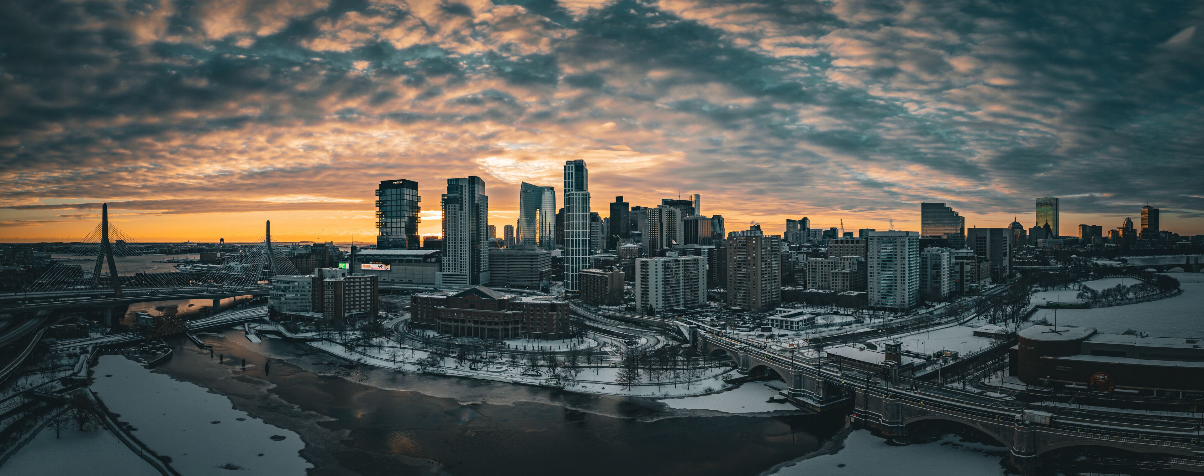 Aerial view of snowy cityscape with river and bridge at dusk, East Cambridge, Massachusetts, United States.