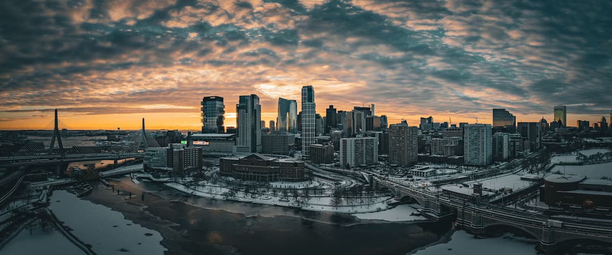 Aerial view of snowy cityscape with river and bridge at dusk, East Cambridge, Massachusetts, United States.