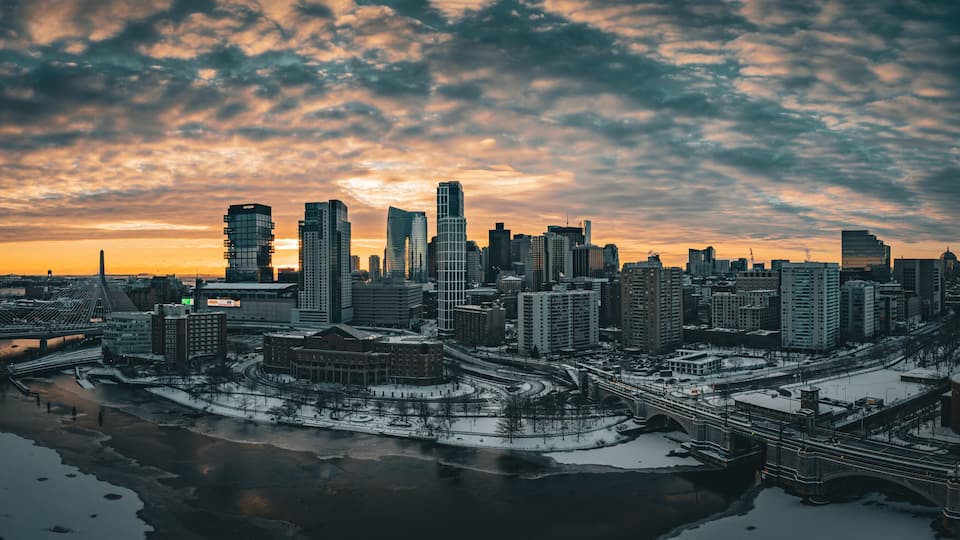 Aerial view of snowy cityscape with river and bridge at dusk, East Cambridge, Massachusetts, United States.