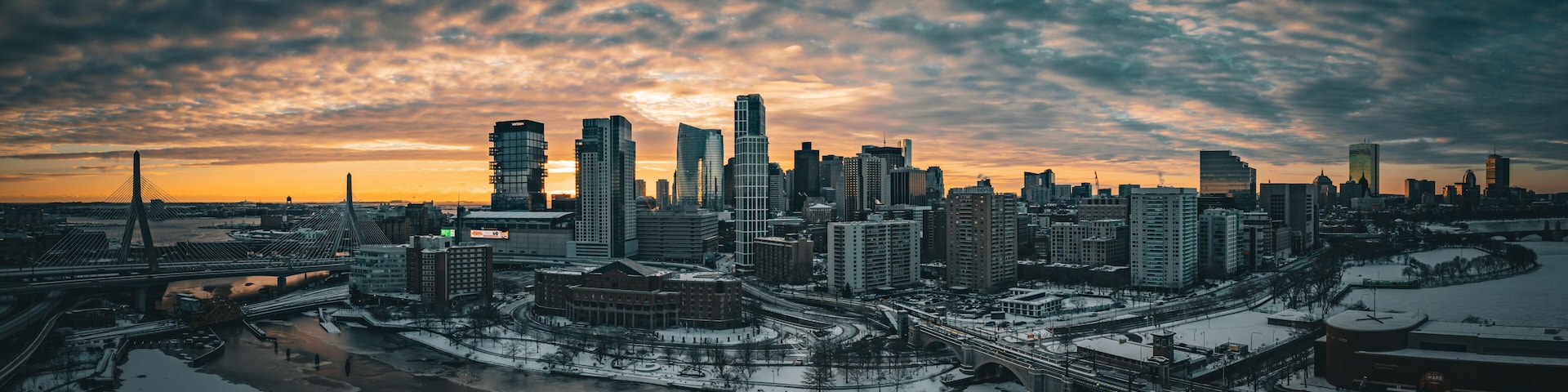 Aerial view of snowy cityscape with river and bridge at dusk, East Cambridge, Massachusetts, United States.
