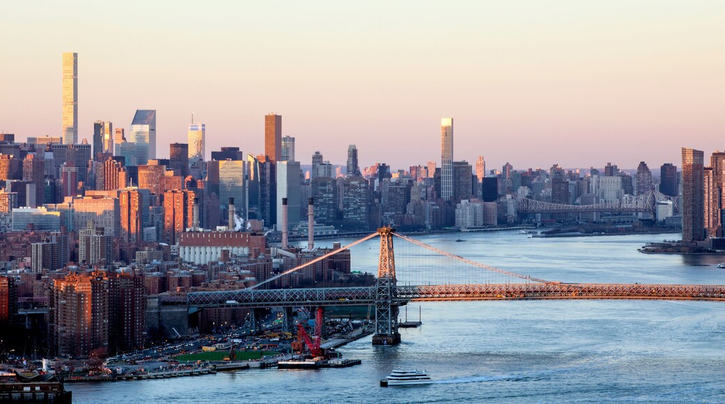 New York City skyline with Williamsburg bridge seen at dusk from Brooklyn with sun reflecting in skyscrapers