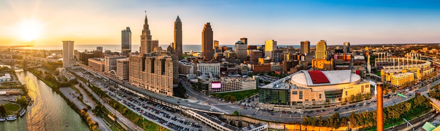 A cityscape with a prominent stadium, a river, and a bridge.