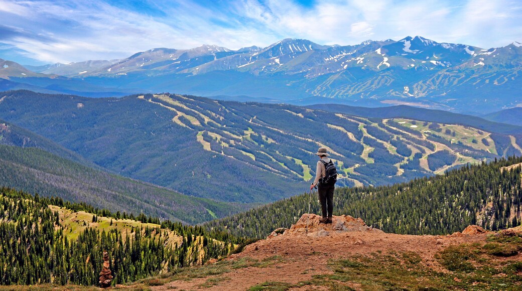 Hiker in Colorado above 12,000 feet on the West Ridge Trail near Loveland Pass with ski runs of Keystone in the background
