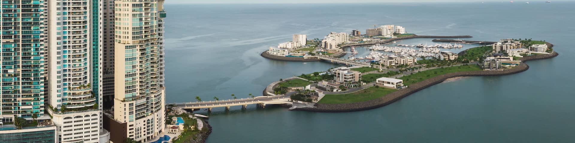 A coastal cityscape with high-rise buildings and a marina.