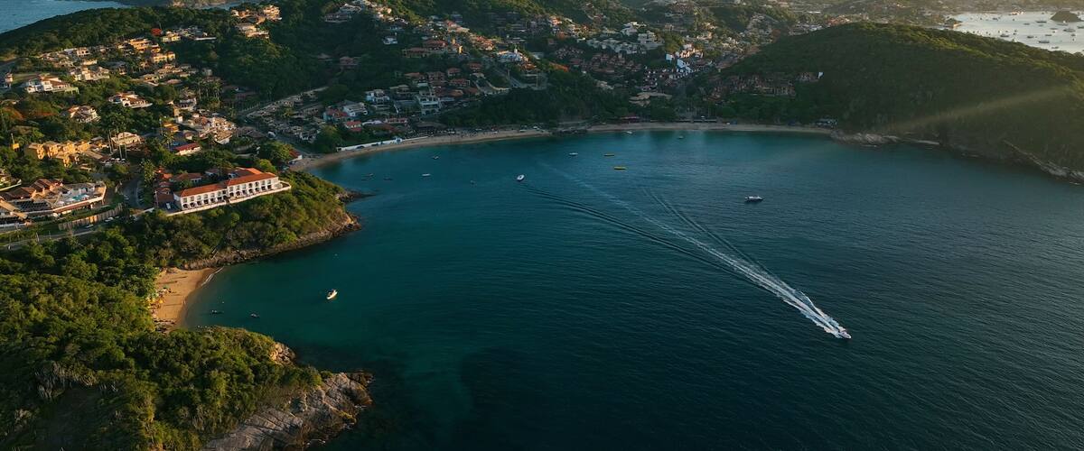 Aerial view of beautiful coastal beach and serene ocean with islands and boats, Armacao dos Buzios, Brazil.