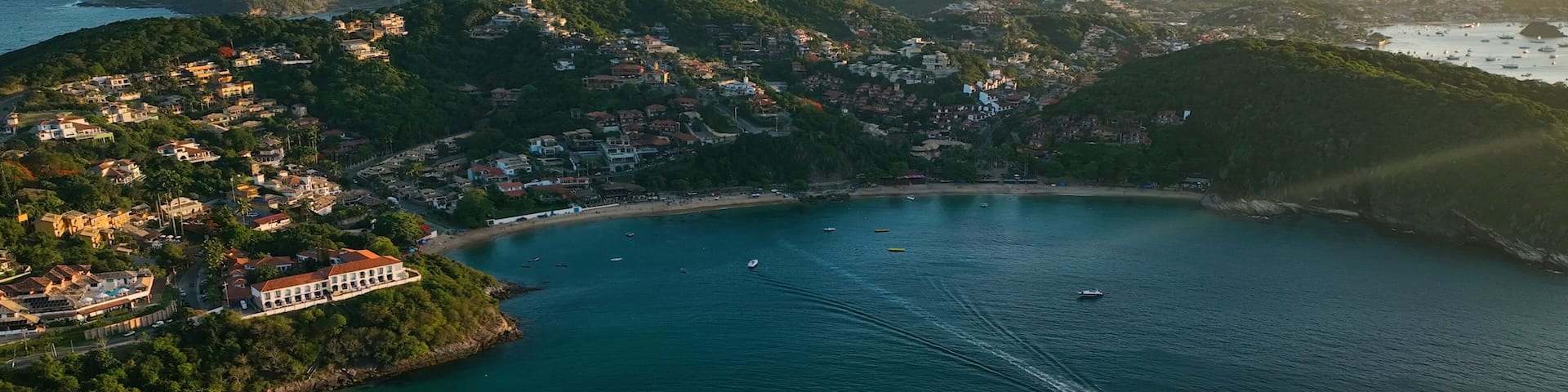 A coastal town with a bay, boats, and a yacht.