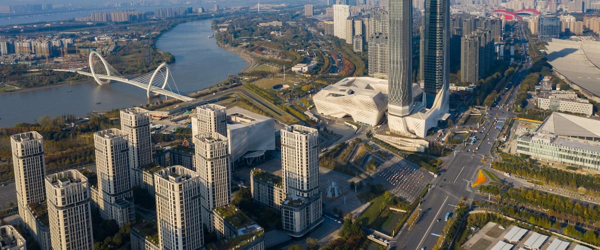 A cityscape with modern skyscrapers, a river, and a distinctive bridge.