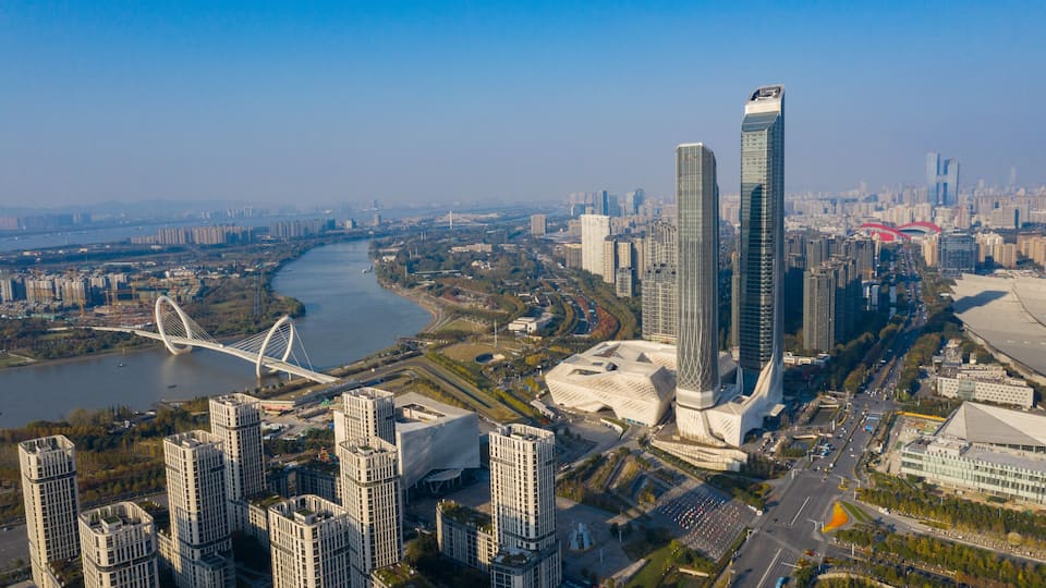 A cityscape with modern skyscrapers, a river, and a distinctive bridge.