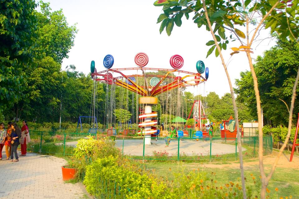 A carousel in a park surrounded by greenery and trees.