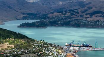 A coastal town with a harbor, surrounded by hills and a large body of water.