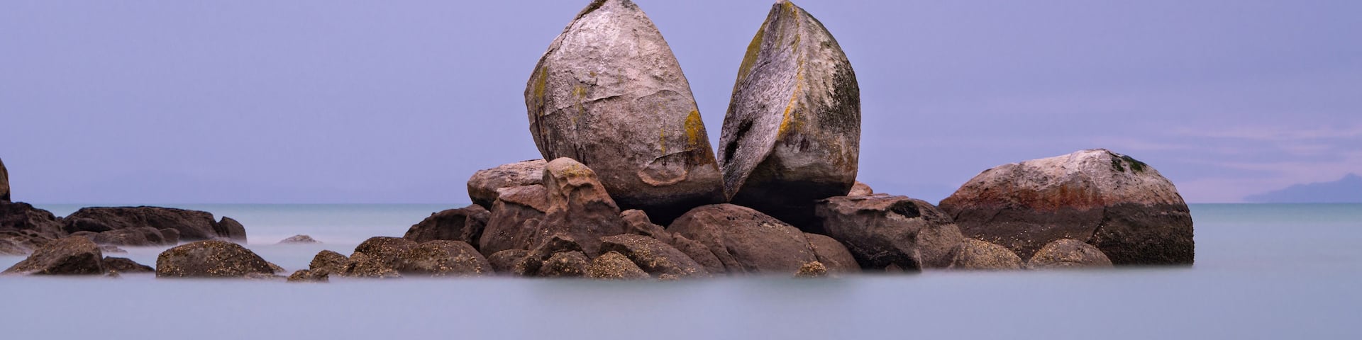 A coastal landscape with prominent rock formations and calm sea.
