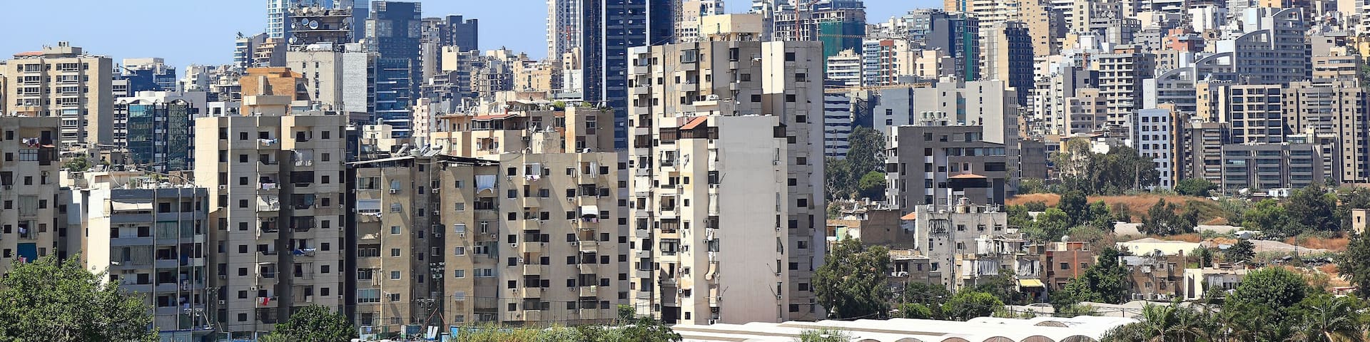 A cityscape with a mix of modern and older buildings, including a distinctive curved skyscraper.