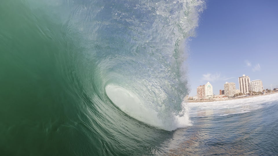 Clean ocean wave surging crashing towards shallow sandbars at surf city beaches of Durban