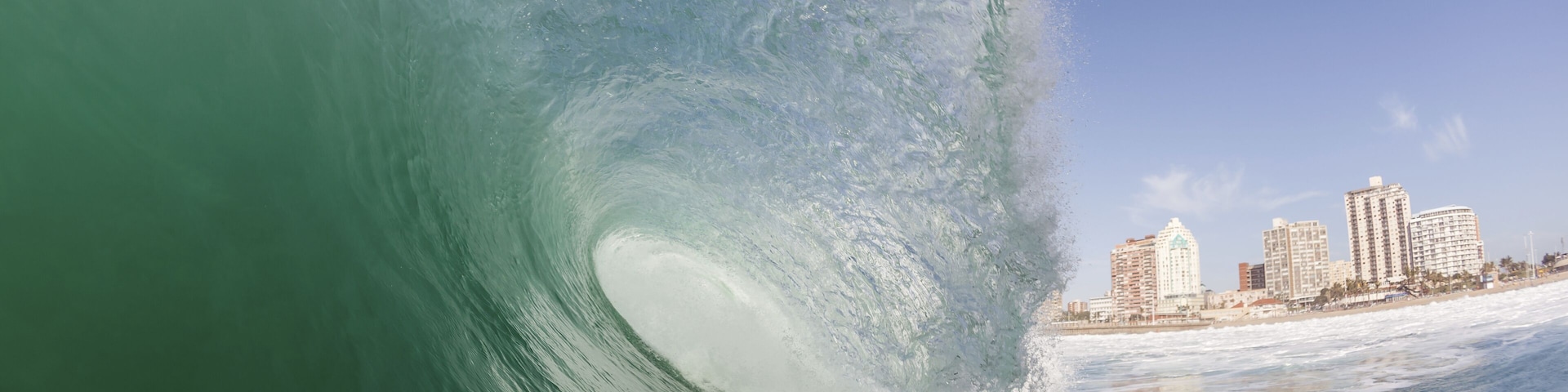 Clean ocean wave surging crashing towards shallow sandbars at surf city beaches of Durban