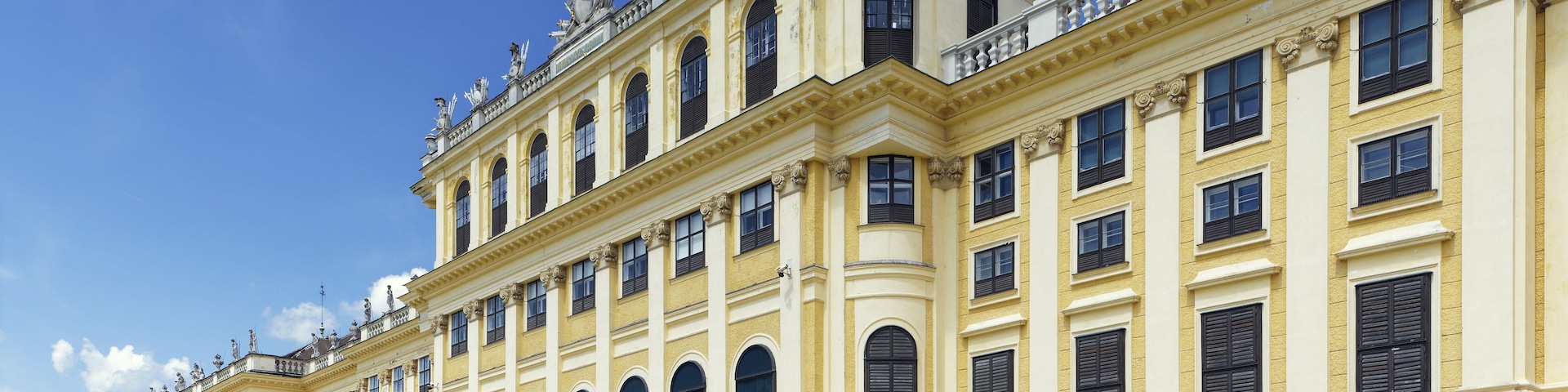 Ein prachtvolles klassizistisches Gebäude mit aufwendigen Skulpturen, einer zentralen Treppe und einer symmetrischen Fassade.