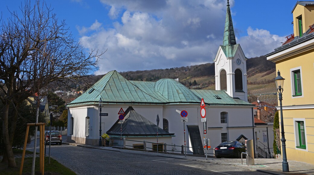 Eine Kirche mit einem grünen Dach und einem hohen Kirchturm.
