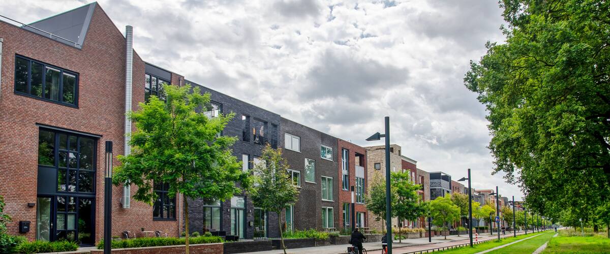 Enschede, The Netherlands, August 9, 2023: long facade with residential buildings along the central axis in reconstructed neighbourhood Roombeek