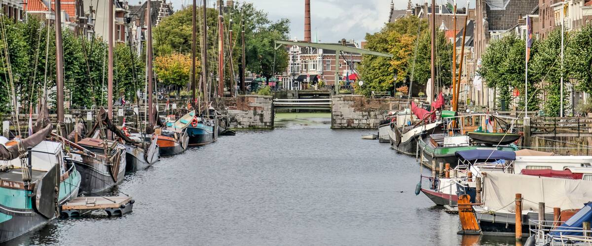 Rotterdam, The Netherlands, October 3, 2021: Voorhaven canal in picturesque Delfshaven neighbourhood, with historic houses and boats and the famous Pilgrim Fathers church
