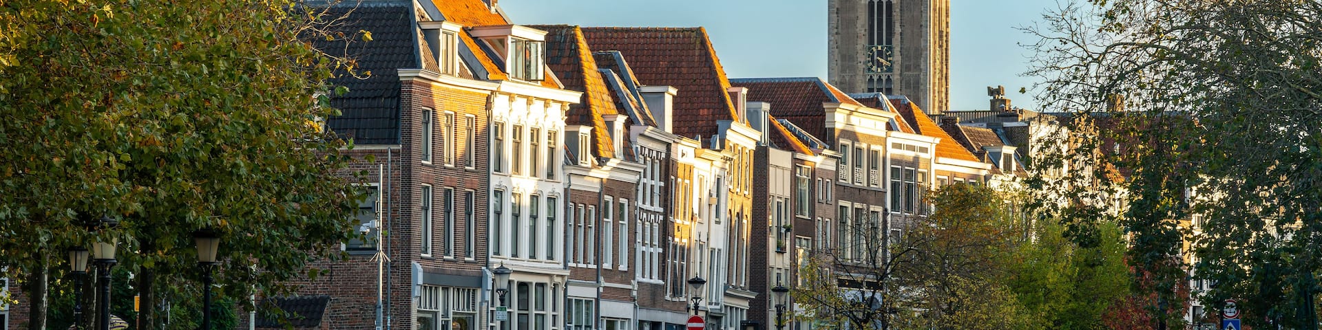 A historic town with traditional architecture, a prominent church tower, and surrounding trees.
