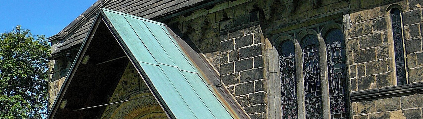 Bell gable, porch and Norman south doorway of the parish church of St John the Baptist, Church Lane, Adel, Leeds, West Yorkshire