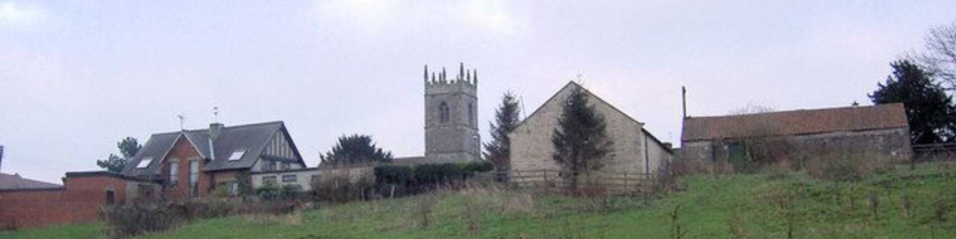 View from Lime Kiln Lane, Stainton, South Yorkshire, across a pasture to the tower of St Winifred's parish church