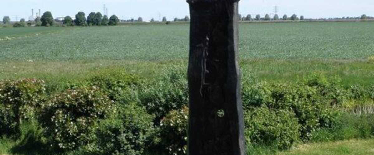 A black sculpture with inscriptions pointing in different directions.
