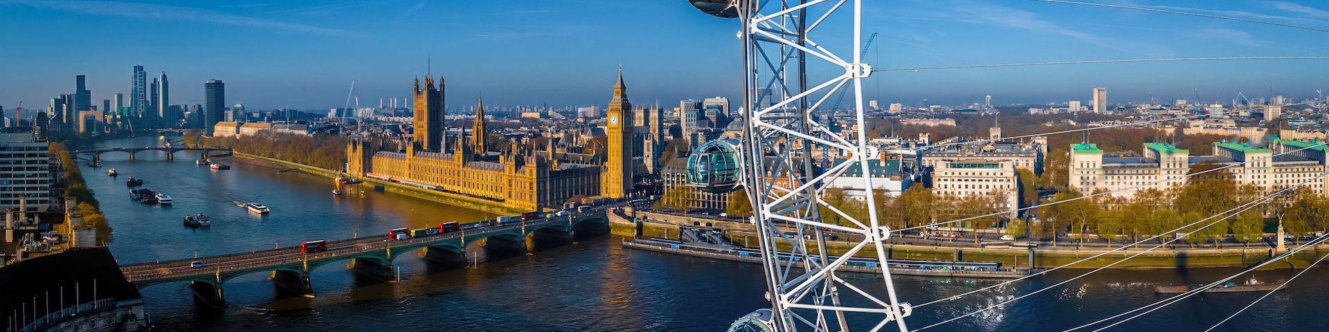Um rio com pontes, uma roda gigante e edifícios históricos, incluindo a torre do relógio Big Ben.