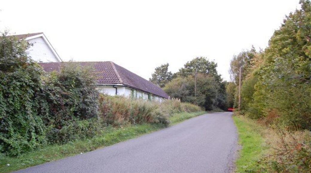 Home Farm Road This view looks north along the road with Home Farm and its outbuilding on the left.
