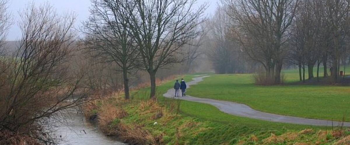 A river with a path and people walking.