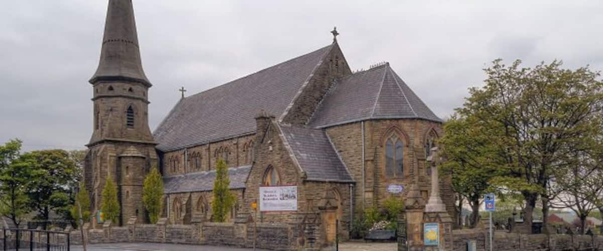 A historic church with a tall steeple and a large arched window.