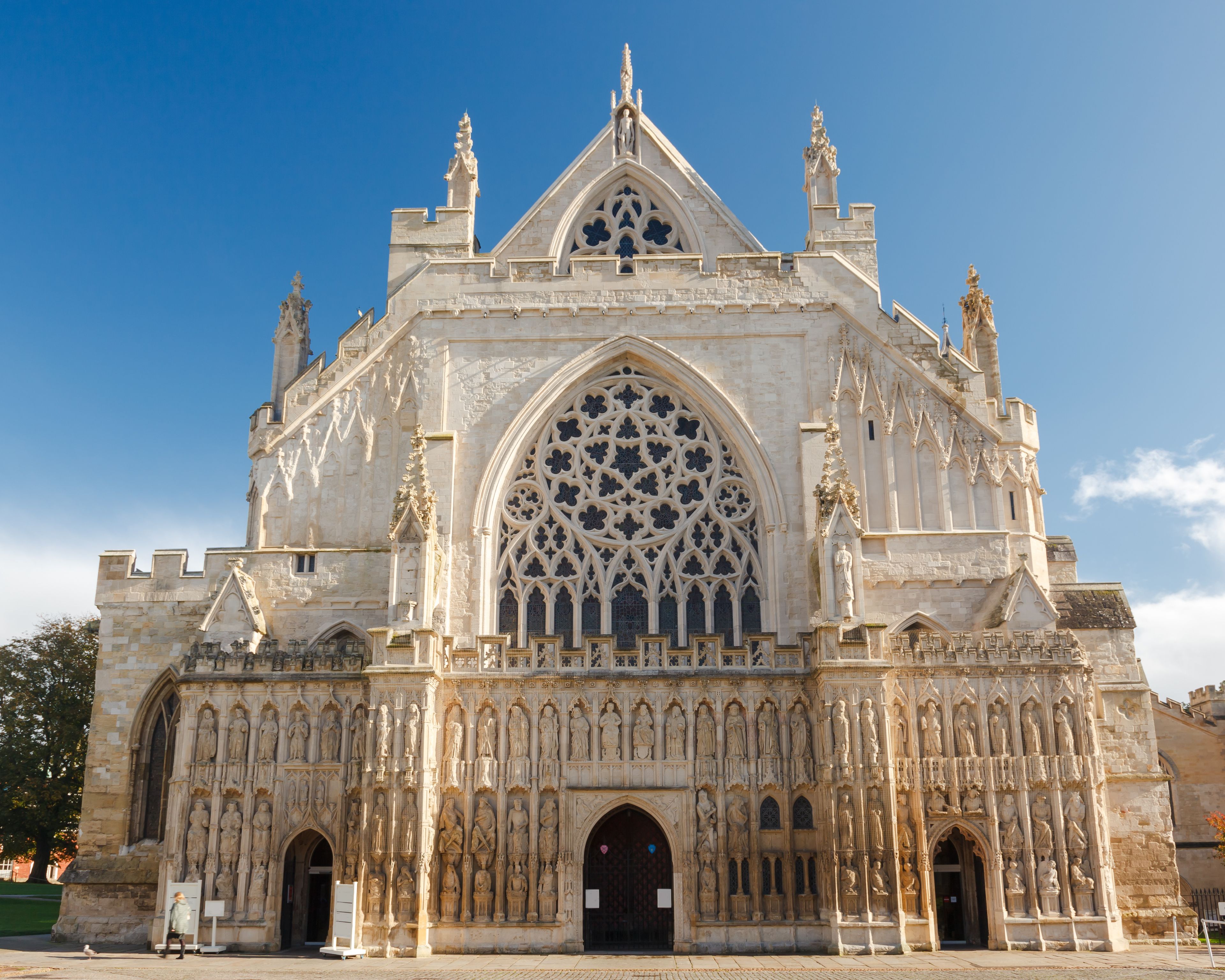 A Gothic cathedral with intricate stone carvings, pointed arches, and a large rose window.