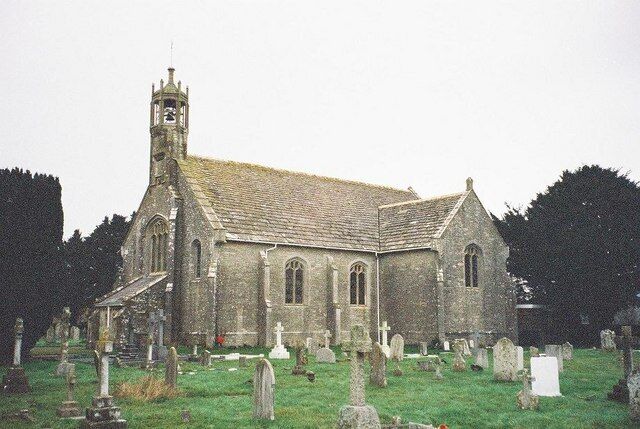 A church with a tall steeple and a graveyard in front.