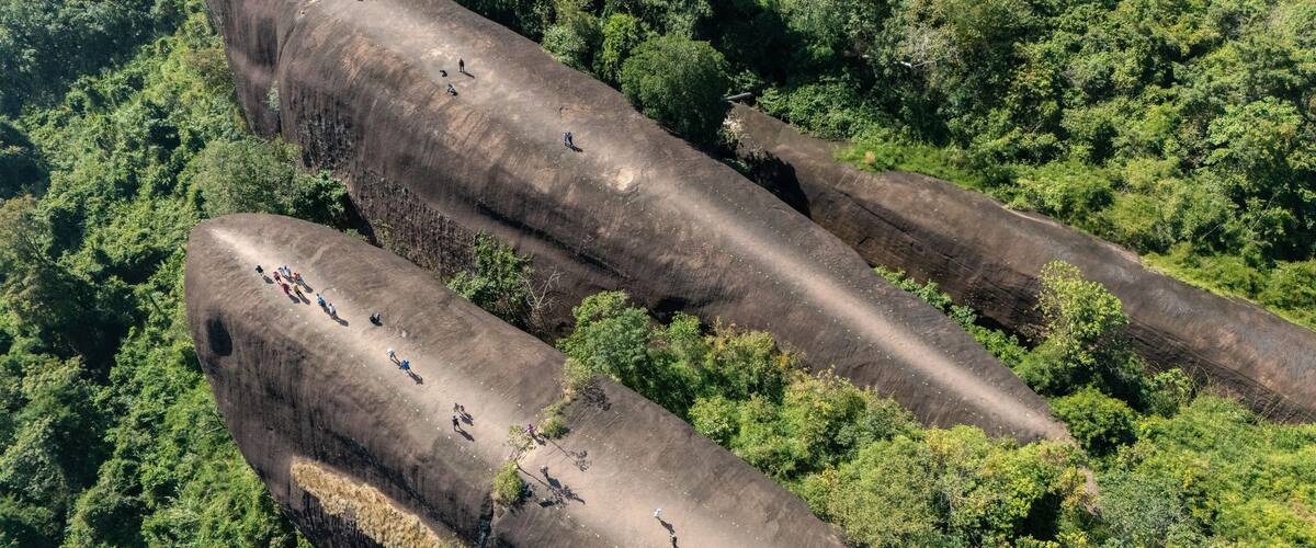 A large rock formation with people walking on it.