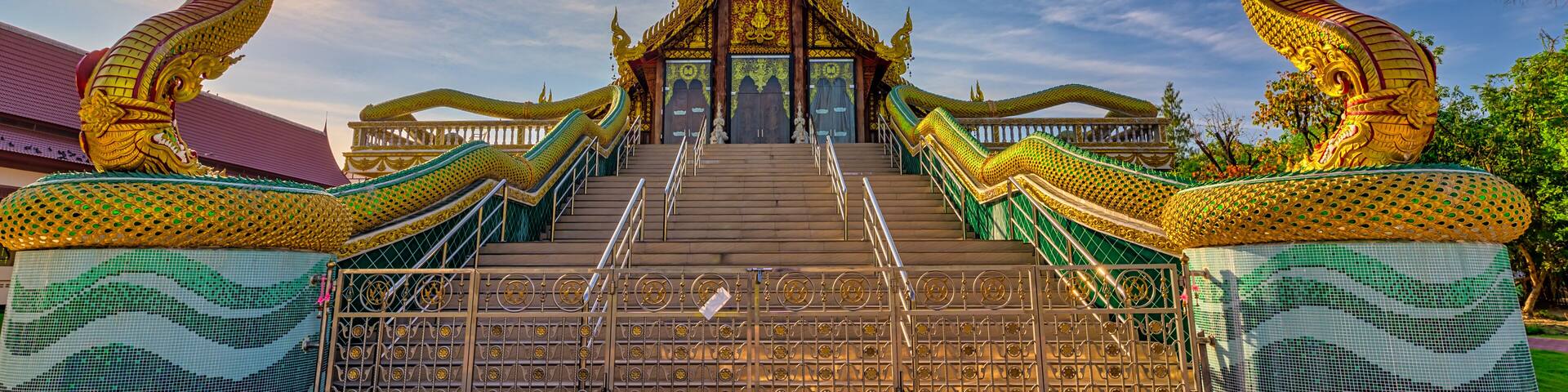 A temple with a golden roof and two large dragon statues on either side.
