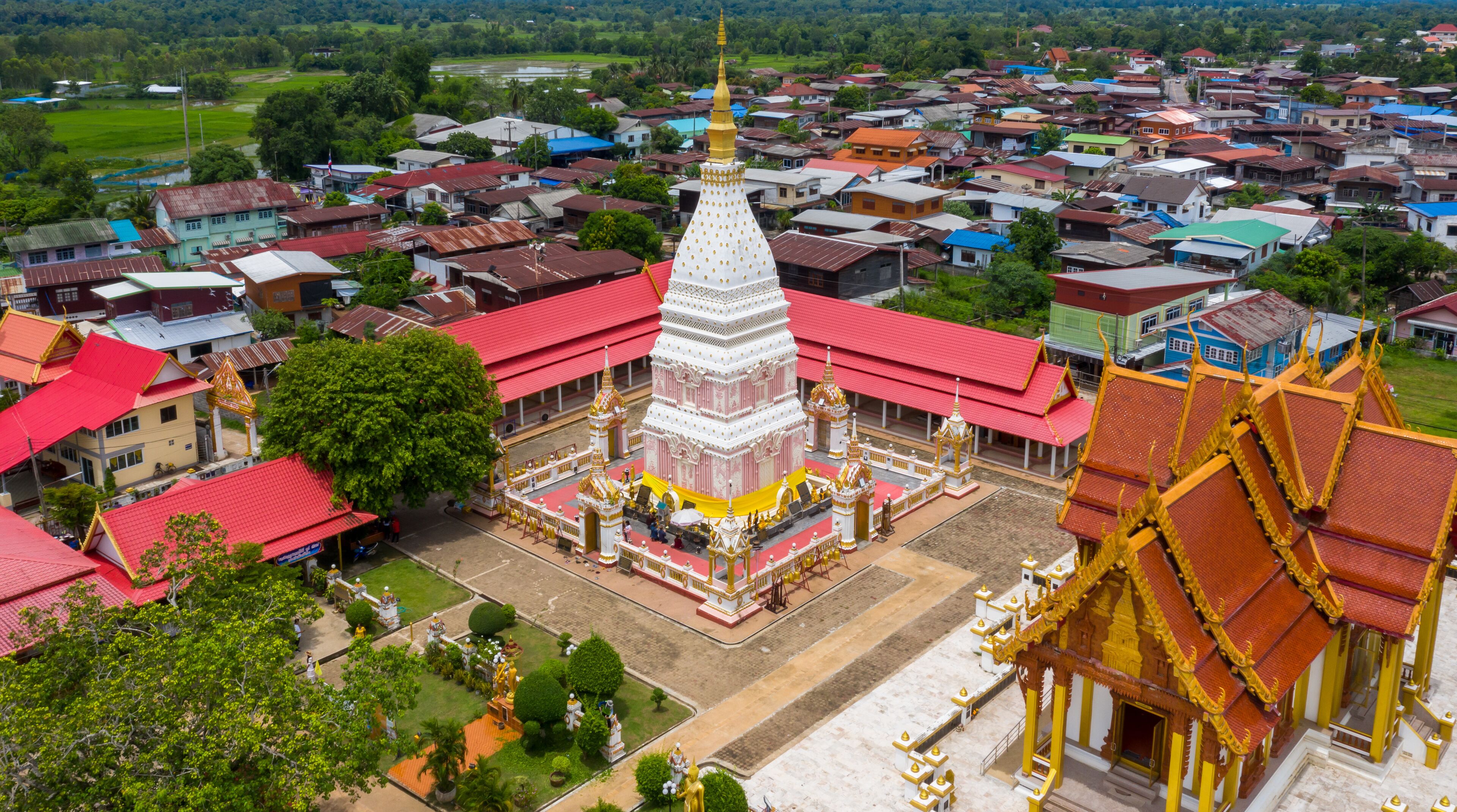 A temple complex with a central stupa, surrounded by smaller buildings and a residential area.