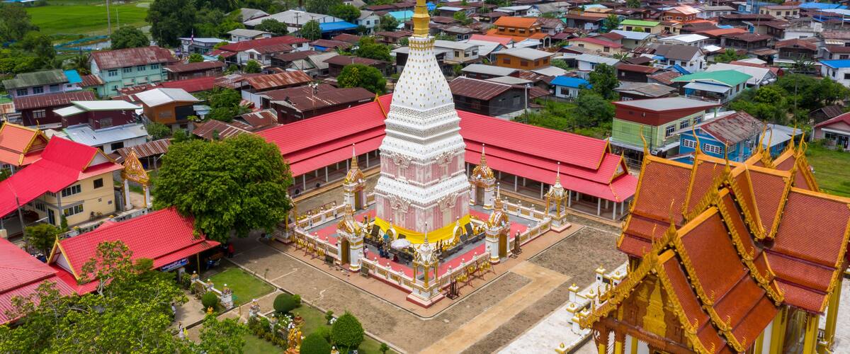 A temple complex with a central stupa, surrounded by smaller buildings and a residential area.