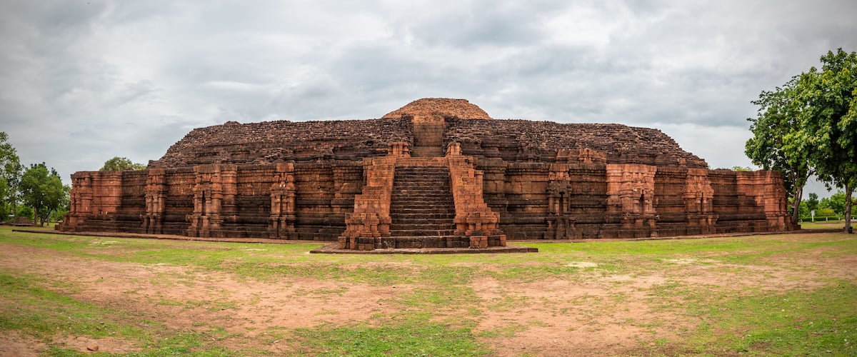 A large, ancient brick temple with a central staircase and a flat-topped structure.